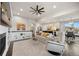 Bright living room with a fireplace, ceiling fan, built-in shelves, and view of the adjacent kitchen at 15156 W Baker Pl, Lakewood, CO 80228
