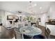 Open-concept living space with a dining table, stylish lighting, and a view into the modern kitchen at 15156 W Baker Pl, Lakewood, CO 80228