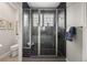 Modern black tiled shower with glass door, and a built in bench, offering a spa-like experience at 15156 W Baker Pl, Lakewood, CO 80228