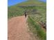 Person running uphill on a dirt trail at 15156 W Baker Pl, Lakewood, CO 80228