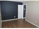 Bedroom featuring dark accent wall, base trim, wood flooring, and an open door to the ensuite at 2517 S Genoa St, Aurora, CO 80013