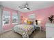 Bright bedroom with windows, featuring a colorful floral bedspread, and ceiling fan at 3636 Sublime Ct, Castle Rock, CO 80108