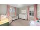 Cozy bedroom with a daybed, crib, natural light, and soft pink curtains at 3636 Sublime Ct, Castle Rock, CO 80108