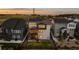 Aerial view of a multi-story home with a fenced yard, deck, and well-maintained lawn at sunset at 3636 Sublime Ct, Castle Rock, CO 80108