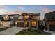 Charming two-story home with a welcoming front porch and well-manicured lawn at dusk at 3636 Sublime Ct, Castle Rock, CO 80108