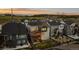 Aerial view of townhomes with fenced yards, decks, and solar panels on the roofs at sunset at 3636 Sublime Ct, Castle Rock, CO 80108