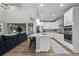 Modern kitchen with white cabinets, stainless steel appliances, and a spacious island with seating at 3636 Sublime Ct, Castle Rock, CO 80108