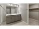Bathroom featuring tiled floors, a double sink vanity, a shower, and a walk-in closet at 27746 E Byers Pl, Aurora, CO 80018