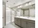 Bathroom featuring tiled floors, a double sink vanity, a walk-in shower, and two doors at 27746 E Byers Pl, Aurora, CO 80018