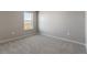This bedroom has gray carpet, light gray walls, and a window for natural light at 27746 E Byers Pl, Aurora, CO 80018