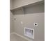 This laundry room has tile floors, white walls, and an open shelf for storage at 27746 E Byers Pl, Aurora, CO 80018