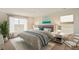 Cozy main bedroom features lots of light, neutral color palette, and modern furnishings at 27746 E Byers Pl, Aurora, CO 80018