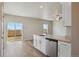 Bright kitchen with white cabinets, quartz countertops, and sliding glass doors at 48280 Shetland Dr, Bennett, CO 80102