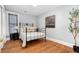 Serene bedroom with classic iron bed frame and hardwood flooring at 3333 W Hayward Pl, Denver, CO 80211