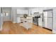 Well-lit kitchen features white cabinetry, stainless steel appliances, and a functional island for meal prep at 3333 W Hayward Pl, Denver, CO 80211