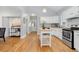 Bright kitchen boasts white cabinetry, a central island, and hardwood floors at 3333 W Hayward Pl, Denver, CO 80211