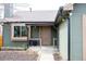 View of a home's front entrance with a covered porch and manicured landscaping at 3943 S Espana St, Aurora, CO 80013