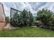 Spacious backyard with lush green lawn, patio, mature trees and landscaped garden areas at 9758 Red Oakes Dr, Highlands Ranch, CO 80126