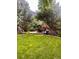 Lush green backyard featuring a patio with outdoor furniture, mature trees, and ample space for recreation at 9758 Red Oakes Dr, Highlands Ranch, CO 80126