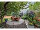 Landscaped backyard with a patio, outdoor seating, and beautiful mature trees and flowers at 9758 Red Oakes Dr, Highlands Ranch, CO 80126