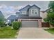 Charming two-story home featuring a well-manicured lawn and two-car garage at 9758 Red Oakes Dr, Highlands Ranch, CO 80126