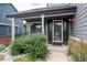 Inviting front porch with seating area, potted plants, and stylish exterior lighting at 9758 Red Oakes Dr, Highlands Ranch, CO 80126