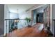 Upstairs hallway with wood floors overlooking the main living space and bright, airy feel at 9758 Red Oakes Dr, Highlands Ranch, CO 80126