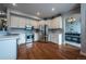 Bright kitchen with stainless steel appliances, white cabinets, hardwood floors, and modern lighting at 9758 Red Oakes Dr, Highlands Ranch, CO 80126