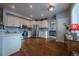 Bright kitchen with stainless steel appliances, white cabinets, hardwood floors, and modern lighting at 9758 Red Oakes Dr, Highlands Ranch, CO 80126
