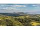 Panoramic view of a beautiful landscape with rolling hills, distant mountains, and green valleys at 9758 Red Oakes Dr, Highlands Ranch, CO 80126