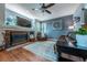 Cozy living room with a stone fireplace, hardwood floors, and comfortable seating, perfect for relaxation at 9758 Red Oakes Dr, Highlands Ranch, CO 80126