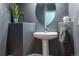 Stylish powder room featuring a pedestal sink, round mirror, and neutral gray walls at 9758 Red Oakes Dr, Highlands Ranch, CO 80126