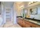 Bathroom with double vanity, wood cabinets, and decorative mirrors at 8864 S Quemoy Ct, Aurora, CO 80016