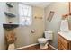 Cozy bathroom with rustic decor, including open shelving and a window with sheer curtains at 4879 S Xenophon St, Morrison, CO 80465