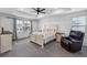 Spacious bedroom with ceiling fan, plush carpeting, and natural light from large windows at 1168 Elbridge Dr, Elizabeth, CO 80107