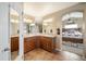 Well-lit bathroom featuring double sinks, wood cabinets and tile floors at 40900 Red Fox Cir, Elizabeth, CO 80107