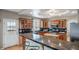 Spacious kitchen featuring a breakfast bar with granite countertops, wood cabinets, and stainless steel appliances at 40900 Red Fox Cir, Elizabeth, CO 80107