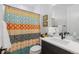 Stylish bathroom with a patterned shower curtain, a modern vanity, and soft lighting, creating a relaxing space at 7077 Copper Sky Cir, Castle Pines, CO 80108