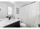 Bright bathroom featuring a sleek vanity with modern black fixtures and a tub with a stylish floral shower curtain at 7077 Copper Sky Cir, Castle Pines, CO 80108