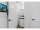 Efficient laundry area with a stacked washer and dryer and convenient storage space in a bright, clean setting at 7077 Copper Sky Cir, Castle Pines, CO 80108