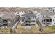 A multilevel rear exterior featuring a stone patio and second story deck with ample backyard space at 7077 Copper Sky Cir, Castle Pines, CO 80108