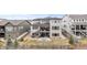 Expansive rear exterior view with a stone patio, grill, staircase and a second story deck at 7077 Copper Sky Cir, Castle Pines, CO 80108