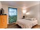 Cozy bedroom featuring neutral paint, patterned curtains, and wood-look floors at 6800 E Tennessee Ave # 461, Denver, CO 80224