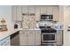 Well-equipped kitchen boasts stainless steel appliances, gray cabinets, modern backsplash, and ample counter space for cooking at 4810 W 8Th Ave, Denver, CO 80204