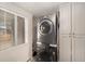 Convenient laundry room with a stacked washer and dryer, ample storage, and a bright window at 4810 W 8Th Ave, Denver, CO 80204