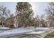 Brick condo building featuring private balcony and mature trees on a snow-covered lawn at 14602 E 2Nd Ave # 303C, Aurora, CO 80011