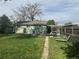 Green home features well kept lawn with mature trees in a fenced backyard at 260 Sheridan Blvd, Denver, CO 80226