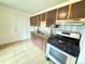 Traditional kitchen with wood cabinets, gas range, and tiled flooring at 260 Sheridan Blvd, Denver, CO 80226
