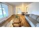 Bright living room featuring wood floors, a comfortable gray sofa, and natural light from a large window at 260 Sheridan Blvd, Denver, CO 80226