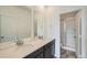 Bathroom featuring double sinks, modern vanity, and a glass-enclosed shower at 702 N Bently St, Watkins, CO 80137